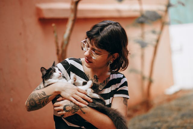 A girl holding her cat in her arms with love and affection.